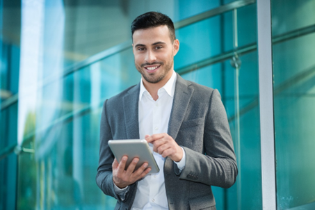 Smiling man with a tablet, representing GBI's innovation in biologics and integration.