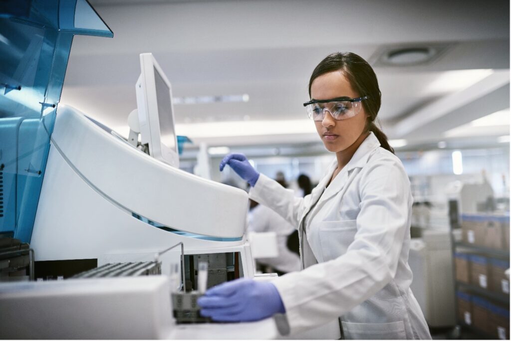 Woman using a machine with a screen in a monoclonal antibody laboratory